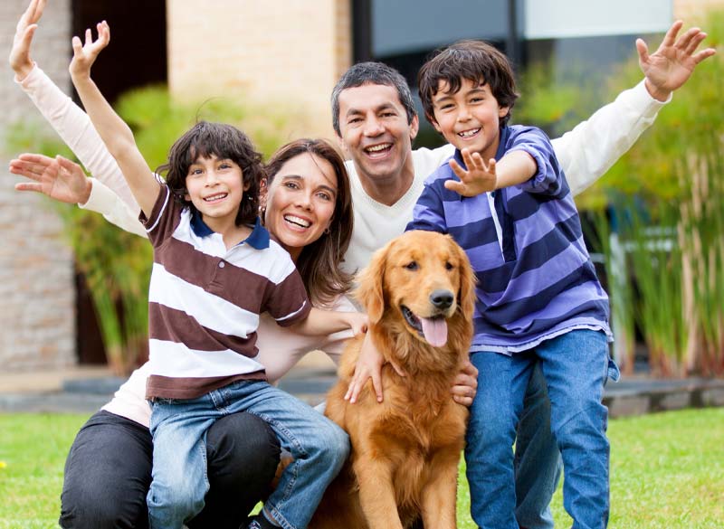 family in front of home with dog